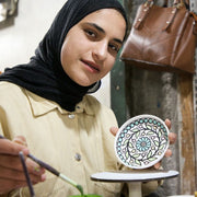 Artisan working with Hand-painted West Bank Appetizer Plates 