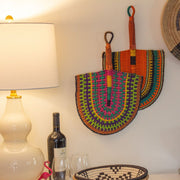 Fair Trade Handwoven River Grass Fan in assorted patterns and colors shown on a wall as decorative elements