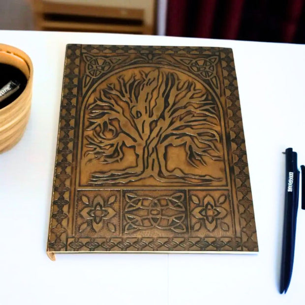Embossed Leather Journal 6" x 8" - Tree of Life next to a pen