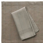 Folded 20" X 20" Hand-woven Cotton Napkin in solid color Cider on top of placemat