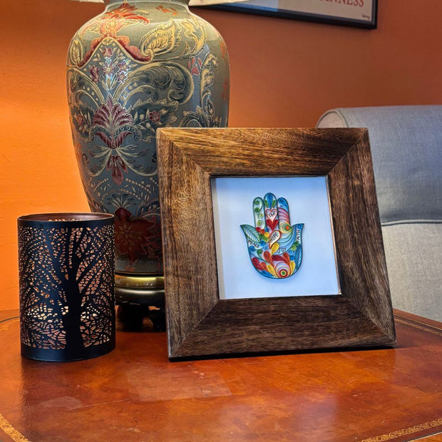 Hamsa Quilled Greeting Card in mango wood square frame on a table next to a iron lantern