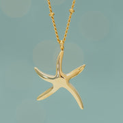 Starfish Hope Necklace in Gold styled against green background