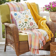 Wicker chair with colorful blankets and an 18-inch Throw Pillow with Embroidered Wildflowers