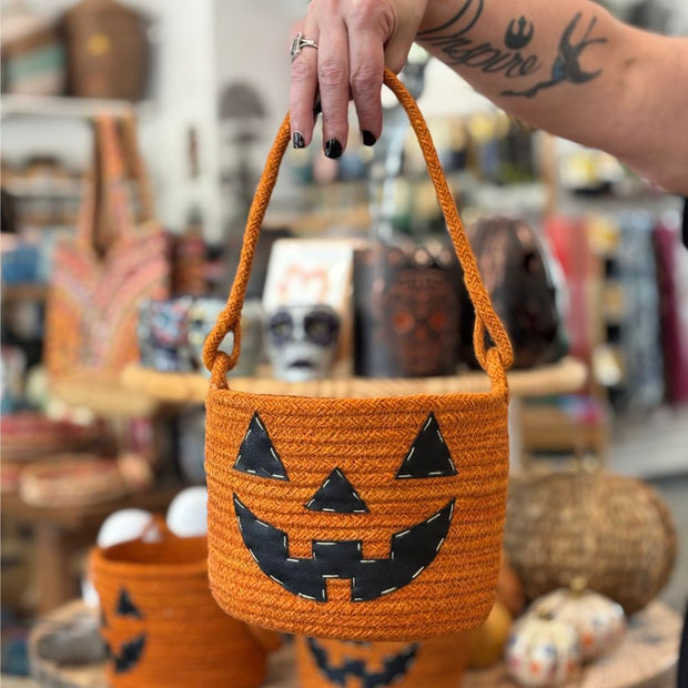 Adult hand holding a Halloween Jack O' Lantern Jute Basket