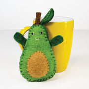 Felt Friendly Avocado Ornament next to a ceramic cup for size comparison