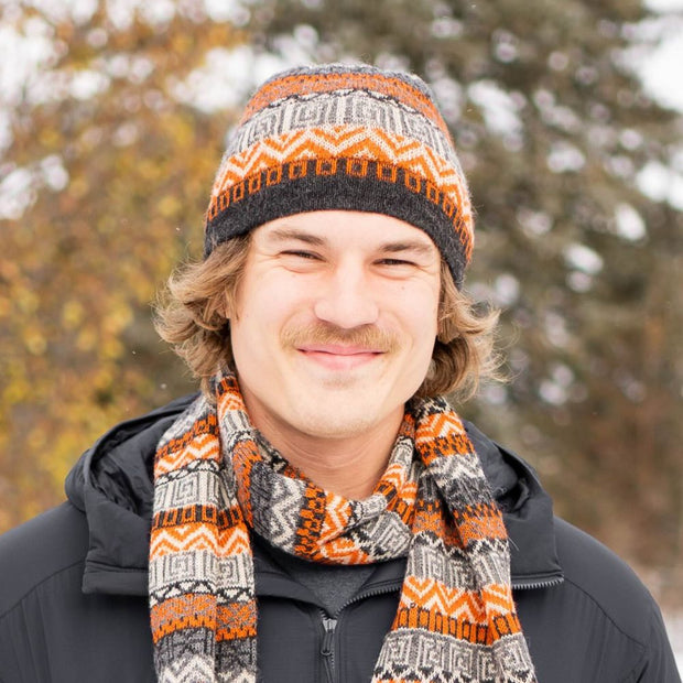 Man wearing a Patterned 100% Baby Alpaca Knitted Beanie Hat in charcoal and orange