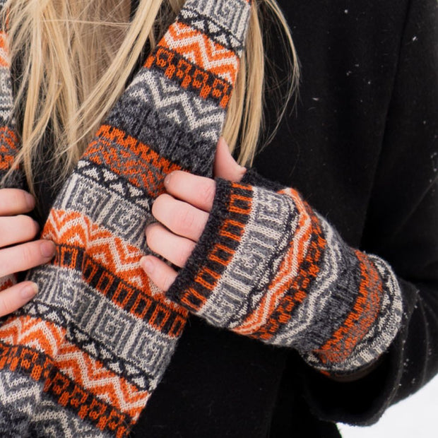 Model wearing a pain of Patterned 100% Baby Alpaca Knit Arm Warmers in charcoal and orange
