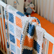 Crocheted Granny Square Baby Blanket hanging from crib