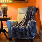 Handmade Chunky Cable Knit Throw draped over an armchair
