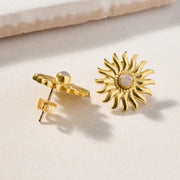 Gold sun-shaped post earrings with a moonstone in the middle showing the back