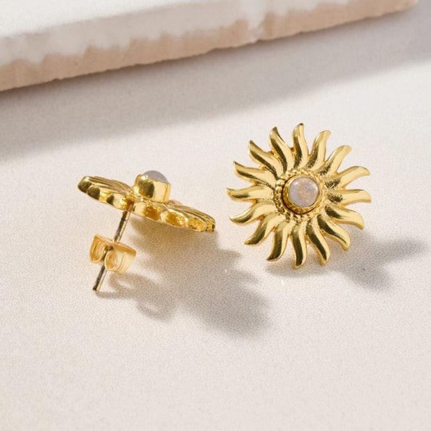 Gold sun-shaped post earrings with a moonstone in the middle showing the back