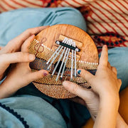 Little hands playing with a Summer Groove Coconut Shell Thumb Piano