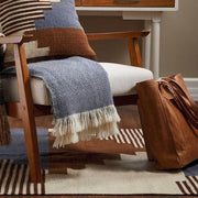 Blue and White Diamond Isla Alpaca Throw Blanket on an armchair