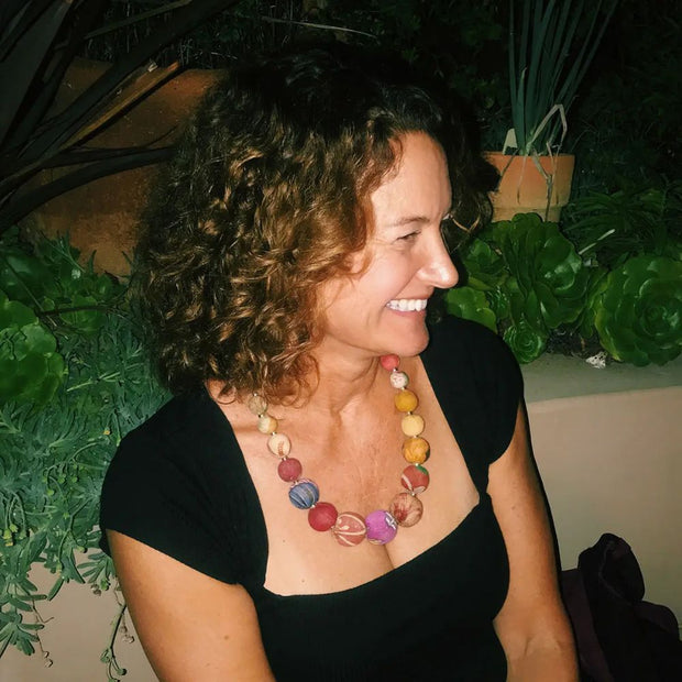 Woman wearing a black dress and a colorful Graduated Bead Statement Necklace 