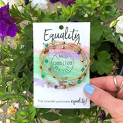 Multi Strand Bracelet set on a card with 'Equality' text, held in front of flowers