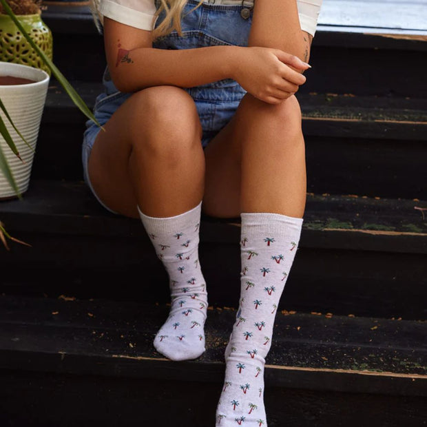 Conscious Step socks that protect tropical rainforests featuring palm trees on model