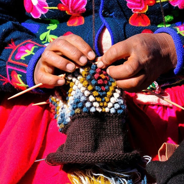 Diamond Hand-knit Ear Warmer showing hands knitting closeup