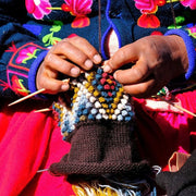 Diamond Hand-knit Ear Warmer showing hands knitting closeup