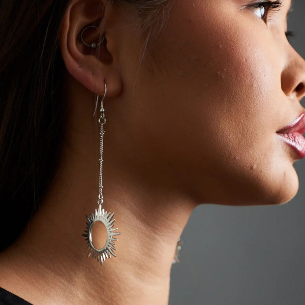 Close-up of a woman wearing Sun-shaped Ethereal Silver Tone Brass Drop Earrings