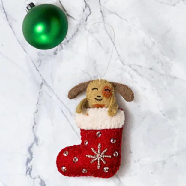 Happy Dog Popping up from Felt Red Stocking Ornament styled next to a green ornament