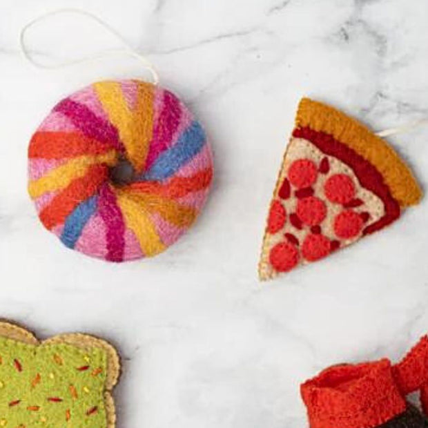 Felt NYC Rainbow Bagel Ornament styled next to a Felt Spice of Pizza Ornament