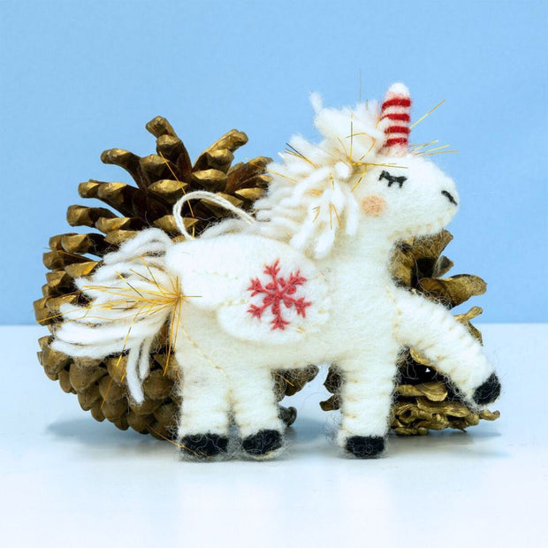 Felt Snowflake Unicorn Ornament styled with pine cones