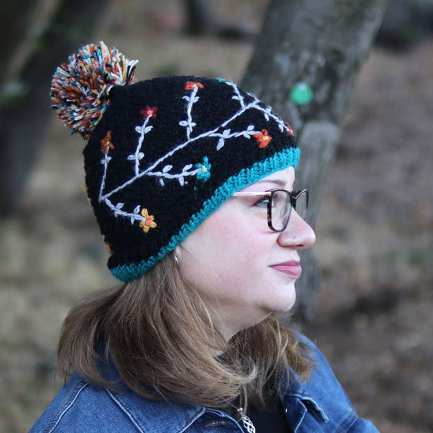 Woman wearing an Andes Gifts Hand-knitted Embroidered Flora Winter Hat in Black
