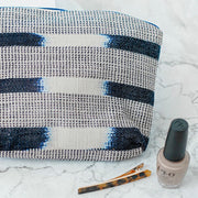 Indigo Cosmetic Travel Bag next to nail polish and hair clip