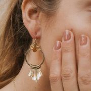 Close-up of a model wearing the Ridhi Citrine and Sunstone Brass Fringe Dangle Earrings