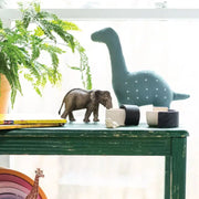 Handmade Stuffed Dinosaur Plush Toy with Kantha stitching on a shelf with other decor