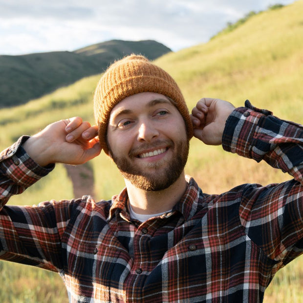 Man wearing a Reversible Milkshake Hand-knit Beanie in Pumpkin Spice color