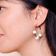 Close-up of a person wearing Multicolor Threaded Hoop Earrings