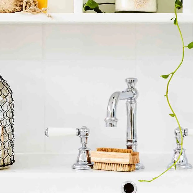 Natural Tampico Eco Max Premium Nail Brush next to a chrome faucet in bathroom