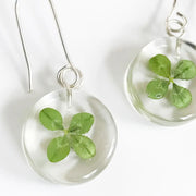 Close up of pair of Clear Resin Mini round Earrings with real-four -leaf Clover