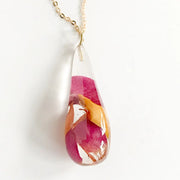 Close up of clear resin tear drop pendant necklace with Rose Petals and Gold Leaf accents