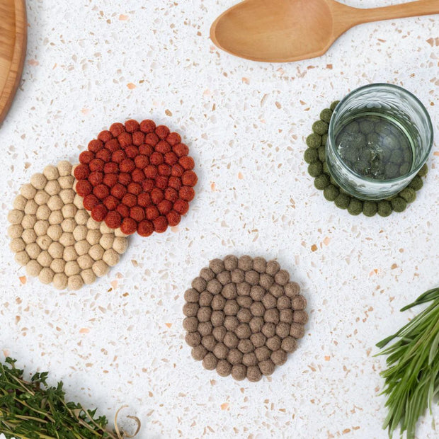 Set of Four Felt Ball Coasters in Solid Harvest colors lifestyle