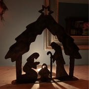Recycled Metal Manger Scene Art shown in the dark with tea light