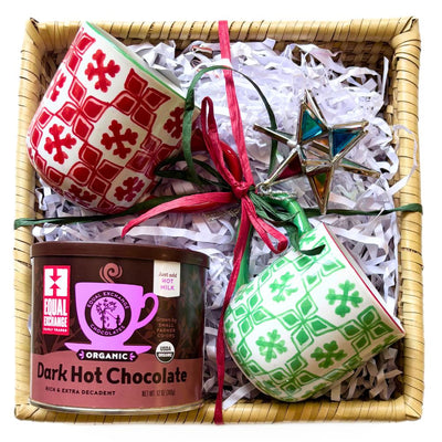Gift basket with mugs, hot chocolate, and decorative star ornament.