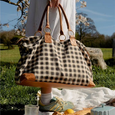Person holding a Carryon Weekender Bag in Ink Gingham print 
