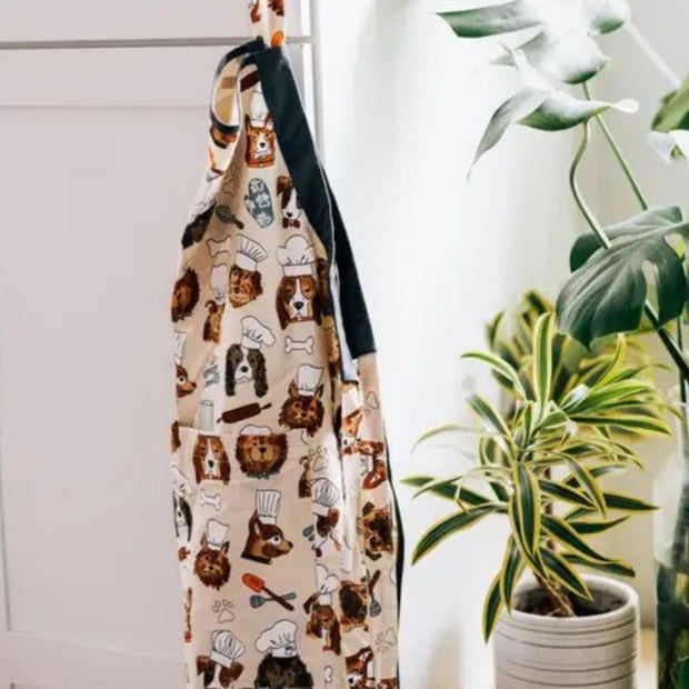 Dog Chefs Cotton Apron hanging on a wall