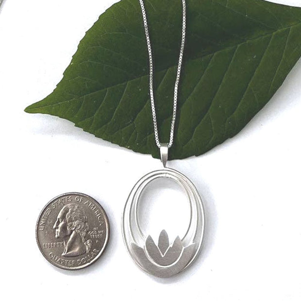 Sterling Silver Lotus Pendant Necklace from Bali, Indonesia next to a US quarter coin for size